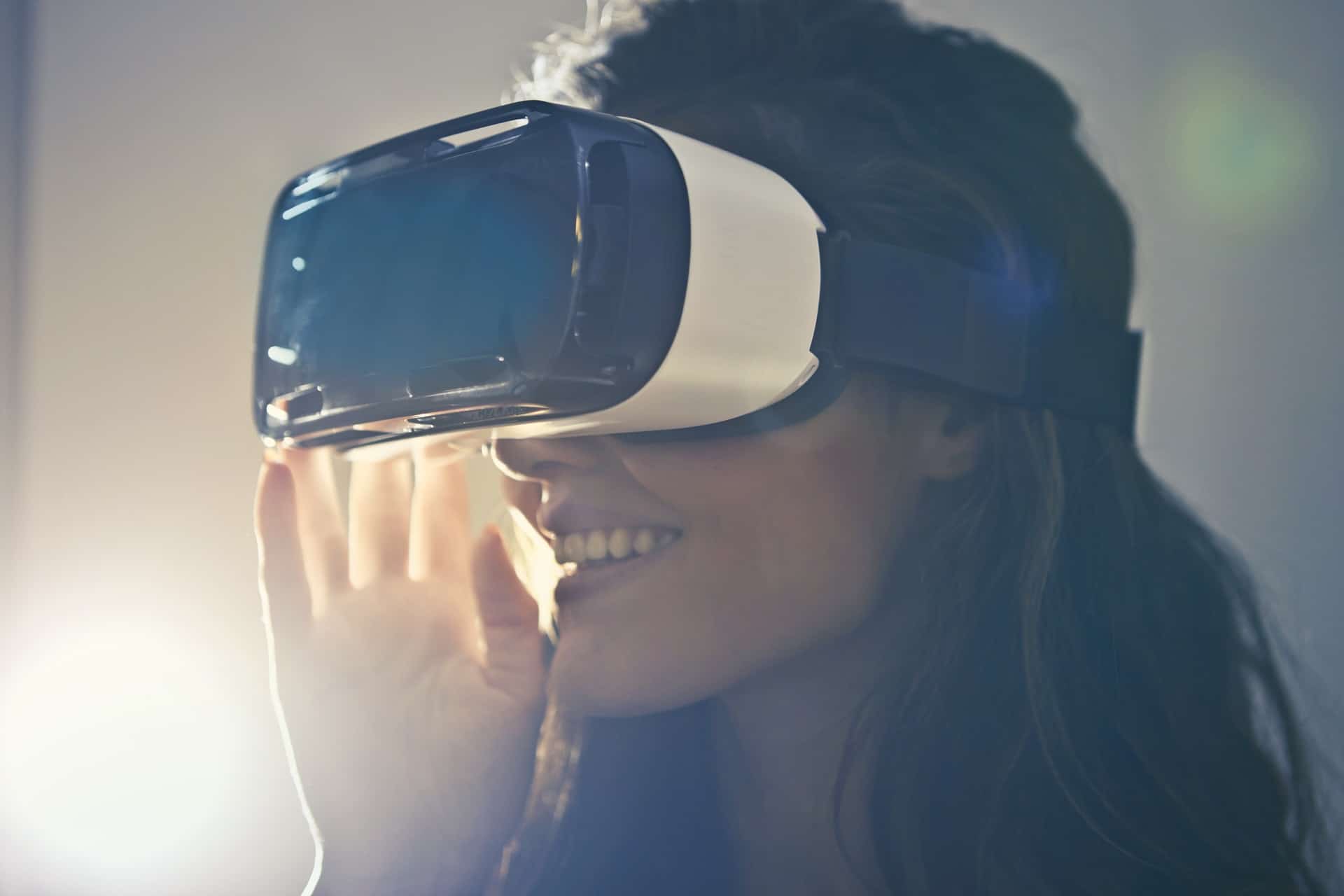 Close-up of a smiling woman wearing a VR headset.